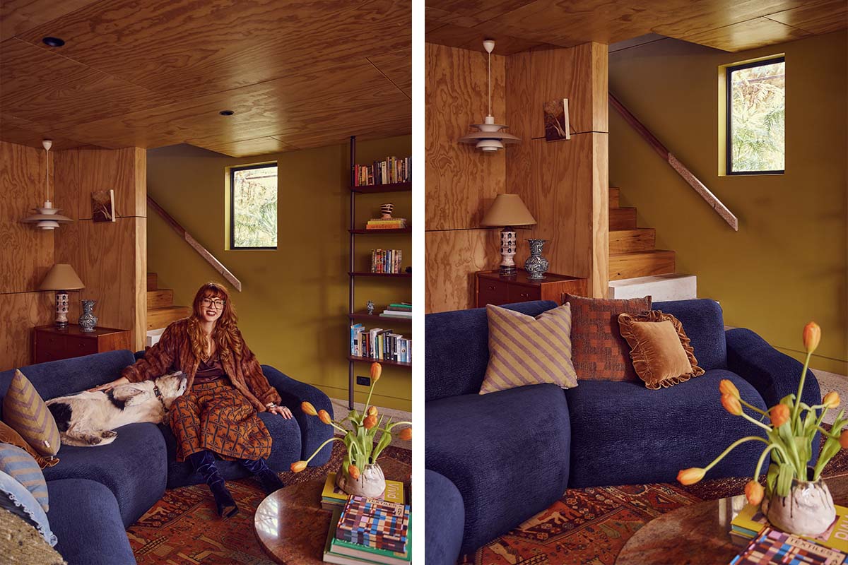 A bold blue modular sofa with deep seats styled with warm reds and rust décor in a maximalist home.